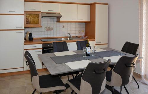 a kitchen with a table and chairs with wine glasses on it at Stunning Apartment In Senj With Wifi in Senj