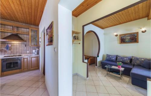 un salon avec un canapé bleu et une cuisine dans l'établissement Apartment Peroj Ii, à Vodnjan