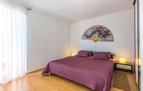 a bedroom with a purple bed and a window at 1 Bedroom Amazing Apartment In Bribir in Bribir