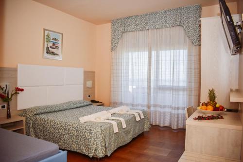 ein Schlafzimmer mit einem Bett und einem Fenster mit Handtüchern darauf in der Unterkunft Hotel Costa Verde in Tortoreto Lido