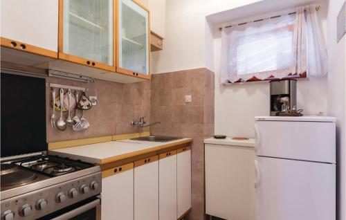 a kitchen with a stove and a white refrigerator at Cozy Apartment In Banjole With Wifi in Banjole