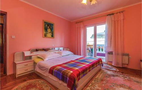 a bedroom with pink walls and a bed and a window at Pet Friendly Apartment In Mundanije With House A Panoramic View in Mundanije