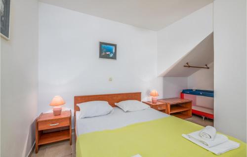 een slaapkamer met een bed en twee nachtkastjes met lampen bij 1 Bedroom Pet Friendly Apartment In Njivice in Njivice