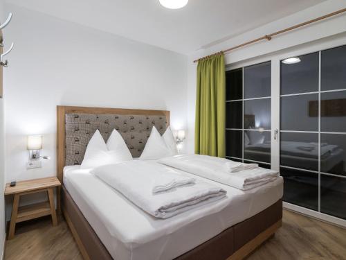 ein Schlafzimmer mit einem großen Bett mit weißer Bettwäsche in der Unterkunft Apartment in St Johann im Pongau with sauna in Alpendorf