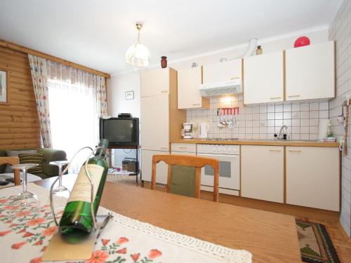 eine Küche und ein Wohnzimmer mit einer Flasche Wein auf dem Tisch in der Unterkunft Cozy apartment in Eberndorf Carinthia near the Petzen ski area in Eberndorf