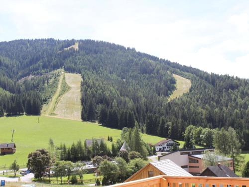 uma vista para uma montanha com um campo verde em Wooden chalet in Hohentauern Styria with sauna em Hohentauern