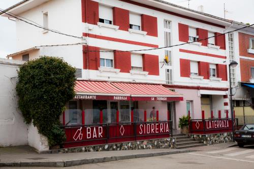 a red and white building with a bar in front of it at Hotel el Horreo de Avilés in Avilés