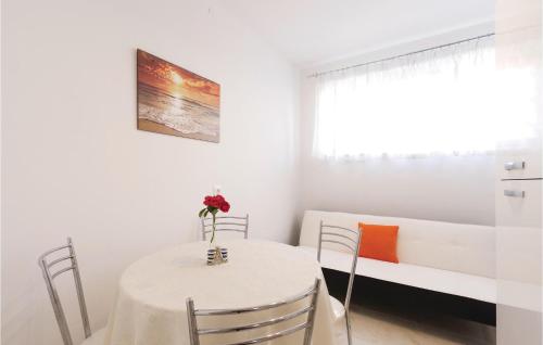 a white dining room with a table and chairs at Apartment Fazana 09 in Fažana