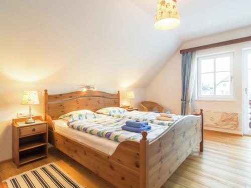 een slaapkamer met een houten bed en een raam bij Tranquil Holiday Home in Kleblach-Lind with Infrared Sauna in Lind