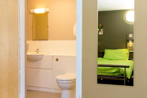 a bathroom with a bed and a toilet and a sink at YHA Berwick in Berwick-Upon-Tweed