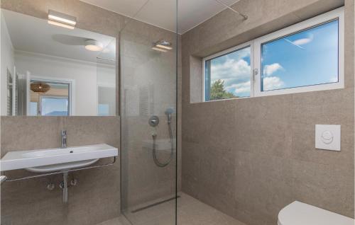 uma casa de banho com um chuveiro, um lavatório e uma janela em Beautiful Apartment In Labin With Kitchen em Labin