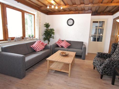a living room with two couches and a coffee table at Charming Chalet near Gro arl with Garden in Grossarl