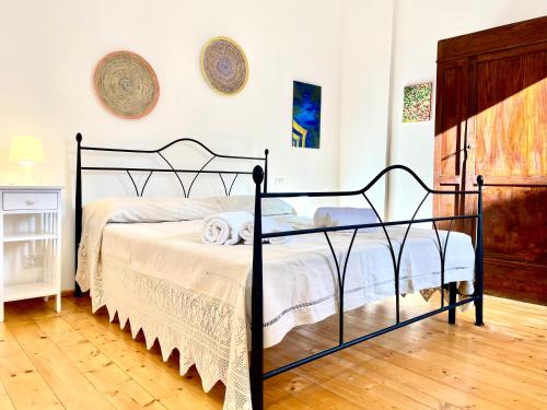 a bedroom with a black metal bed in a room at Le Corti Sarde Apartments in Bari Sardo