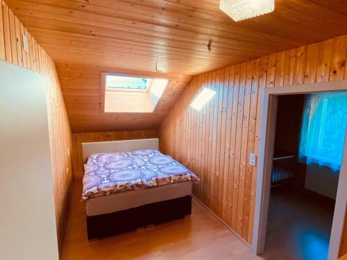 a small room with a bed in a wooden cabin at Holiday apartment in Salchau near ski area 