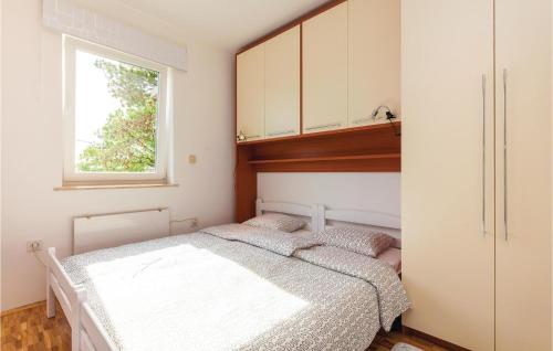 a bedroom with two beds and a window at Amazing Home In Novi Vinodolski With Kitchen in Novi Vinodolski