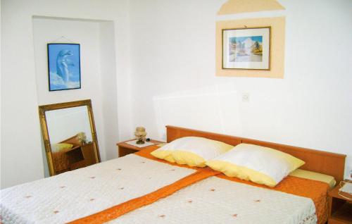 a bedroom with a bed with two pillows and a mirror at Awesome Apartment In Rakalj With House Sea View in Rakalj