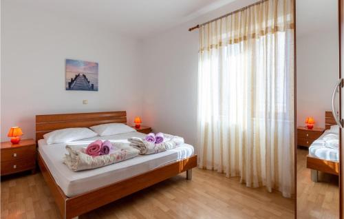 Un dormitorio con una cama con toallas moradas. en Nice Apartment In Novi Vinodolski With Wifi, en Novi Vinodolski