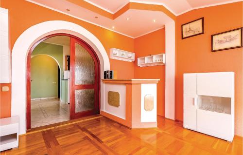 a room with orange walls and an arched doorway at Lovely Apartment In Crikvenica With Outdoor Swimming Pool in Crikvenica