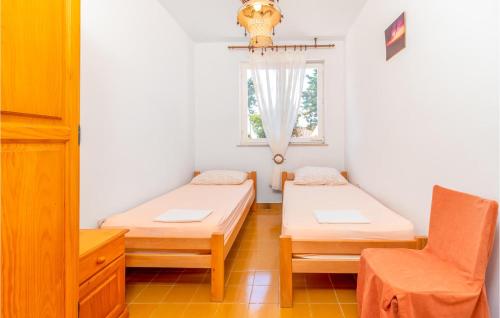 a room with two beds and a window at 3 Bedroom Nice Apartment In Klenovica in Klenovica