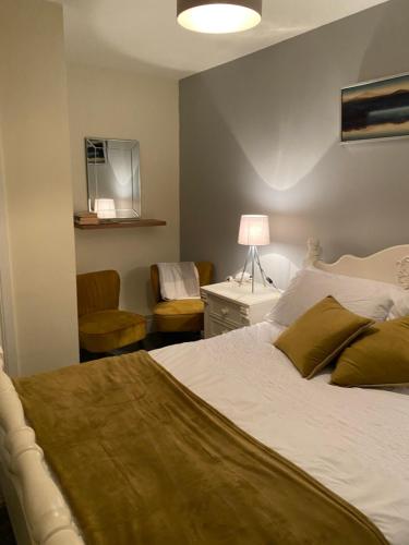 een slaapkamer met een bed, een bureau en een stoel bij The Strand Guest House in Falcarragh