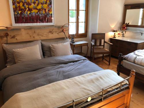 a bedroom with a large bed and a desk at Heidi's Guesthouse in Frenières