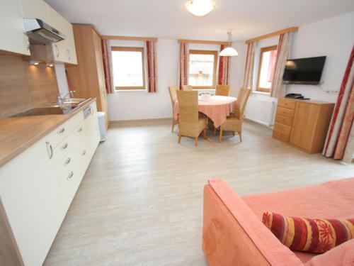 ウダーンスにあるSpacious Apartment in Uderns near Ski Areaのキッチン、リビングルーム(テーブル付)、キッチン、ダイニングルームが備わります。