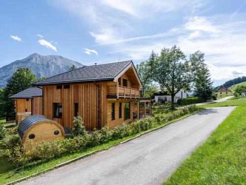 una casa de madera con una carretera delante de ella en Chalet in Tauplitz with sauna in ski area en Tauplitz