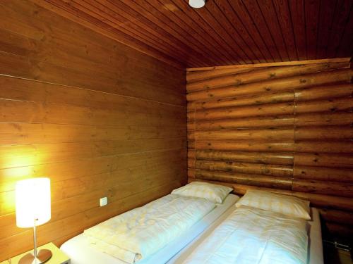バート・ヘーリングにあるSpacious Chalet near Ski Slopes in Worglの木製の壁にベッド2台が備わる小さな客室です。