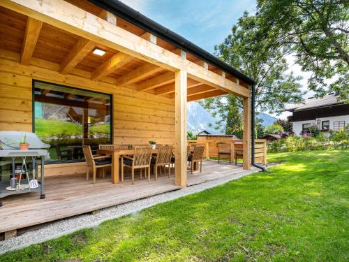 eine Holzterrasse mit einem Tisch und Stühlen in der Unterkunft Chalet in Tauplitz with sauna in ski area in Tauplitz