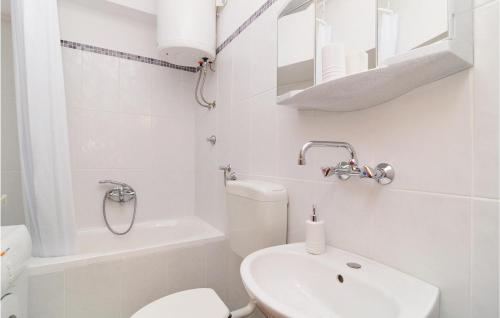a white bathroom with a toilet and a sink at Awesome Apartment In Sibenik With 1 Bedrooms And Wifi in Šibenik