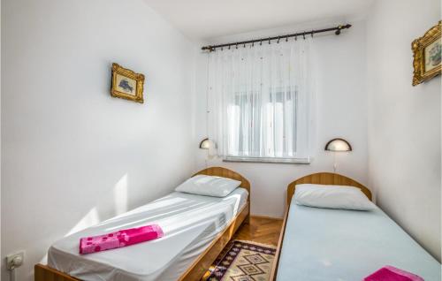 two beds in a small room with a window at Stunning Apartment In Silo With Kitchen in Šilo