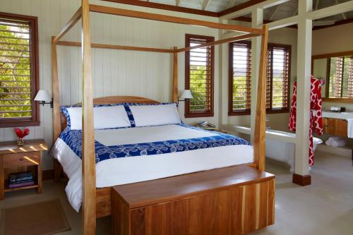 a bedroom with a canopy bed and windows at GoldenEye in Oracabessa