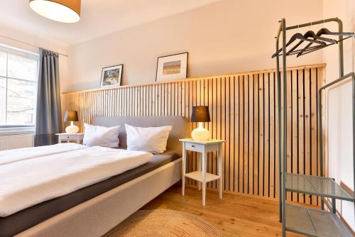 1 dormitorio con 1 cama y pared de madera en Ferienwohnungen im Bürgermeisterviertel en Stralsund