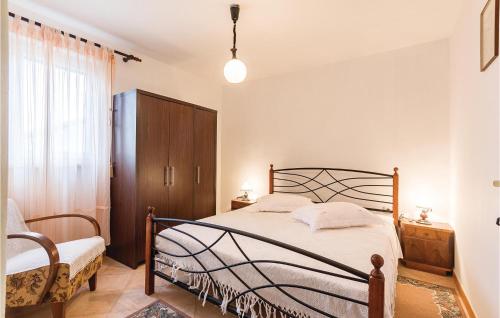 a bedroom with a bed and a chair and a window at Nice Apartment In Banjole With Wifi in Banjole