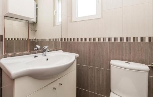 a bathroom with a sink and a toilet and a mirror at 2 Bedroom Stunning Apartment In Povljana in Povljana