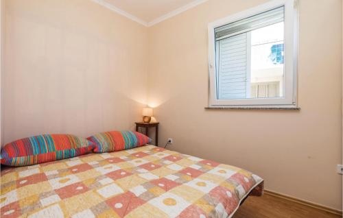 a bedroom with a bed and a window at 2 Bedroom Stunning Apartment In Povljana in Povljana