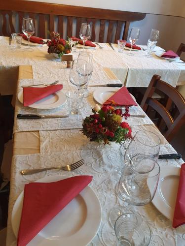 a long table with white plates and red napkins at Antica Osteria Ghiridone in Palagnedra