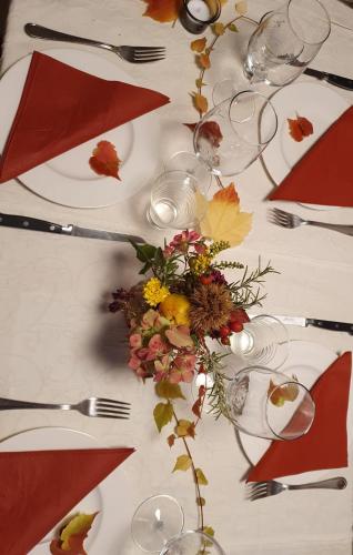a table with a white table cloth with a flower arrangement at Antica Osteria Ghiridone in Palagnedra