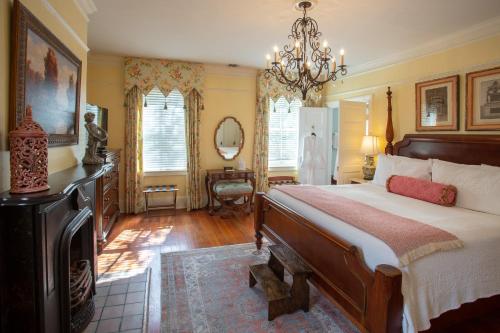 a bedroom with a large bed and a chandelier at The Gastonian, Historic Inns of Savannah Collection in Savannah