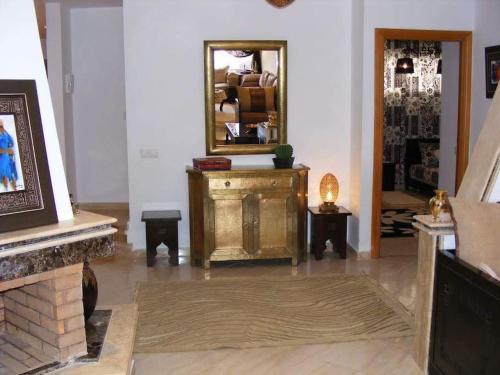 Habitación con espejo en la pared y mesa. en Appartement Hamria Meknes en Meknès