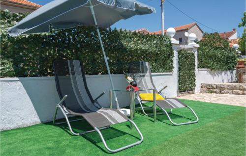 two chairs and an umbrella on a lawn at Awesome Apartment In Zadar With Wifi in Zadar