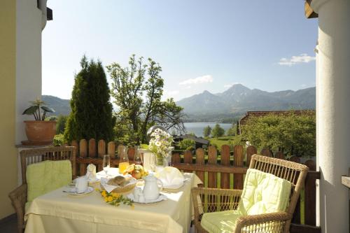 a table and chairs on a balcony with a view at Biohof Naturzeit Faaker See in Drobollach am Faakersee