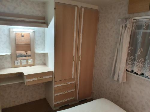 ein Schlafzimmer mit einem Schrank und einem Spiegel in der Unterkunft Bałtyckie Zacisze - Domki holenderskie w Bobolinie, ul Darlowska 11a in Dąbki