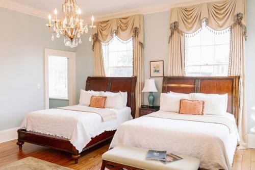 a bedroom with two beds and a chandelier at The Gastonian, Historic Inns of Savannah Collection in Savannah