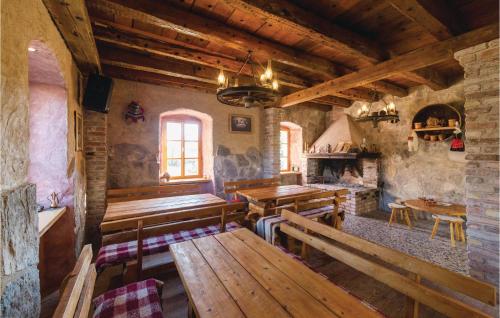 - un salon avec des bancs en bois et une cheminée dans l'établissement Three-Bedroom Holiday Home In Lecevica, à Lećevica