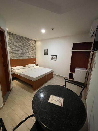 a bedroom with a bed and a table and a table sidx sidx sidx at Hotel Estrela da Agua Fria in Sao Paulo