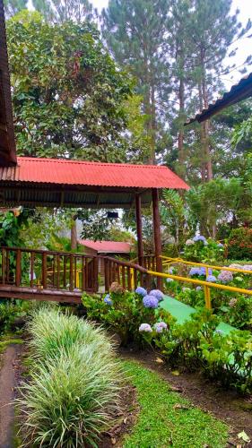 a garden with a wooden gazebo and flowers at Vista Turrialba Lodge in Turrialba