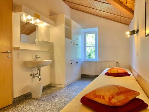 ein Bad mit einem Bett und einem Waschbecken in einem Zimmer in der Unterkunft Hotel&Hostel Montarina in Lugano