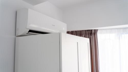 a room with a white cabinet and a window at Sea View Apartments Olimp - Avenue Hotels in Olimp