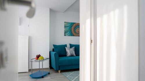 a blue chair in a room with a table at Sea View Apartments Olimp - Avenue Hotels in Olimp